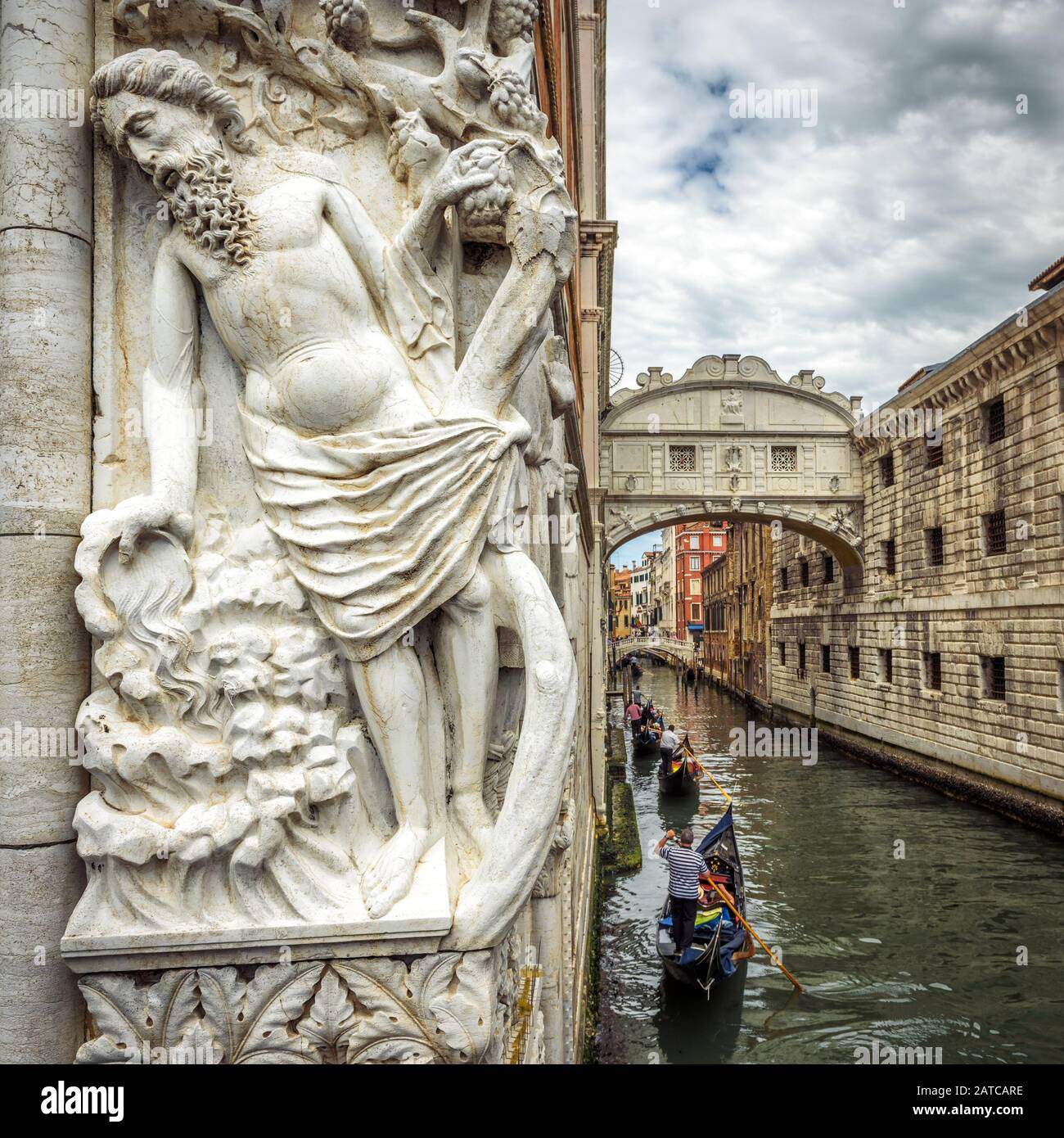 Venedig Stadtbild mit alter Skulptur, Italien. Touristengondeln segeln unter der berühmten Brücke von Sighs. Es ist ein Wahrzeichen Venedigs. Romantischer Wassertrip auf Stockfoto