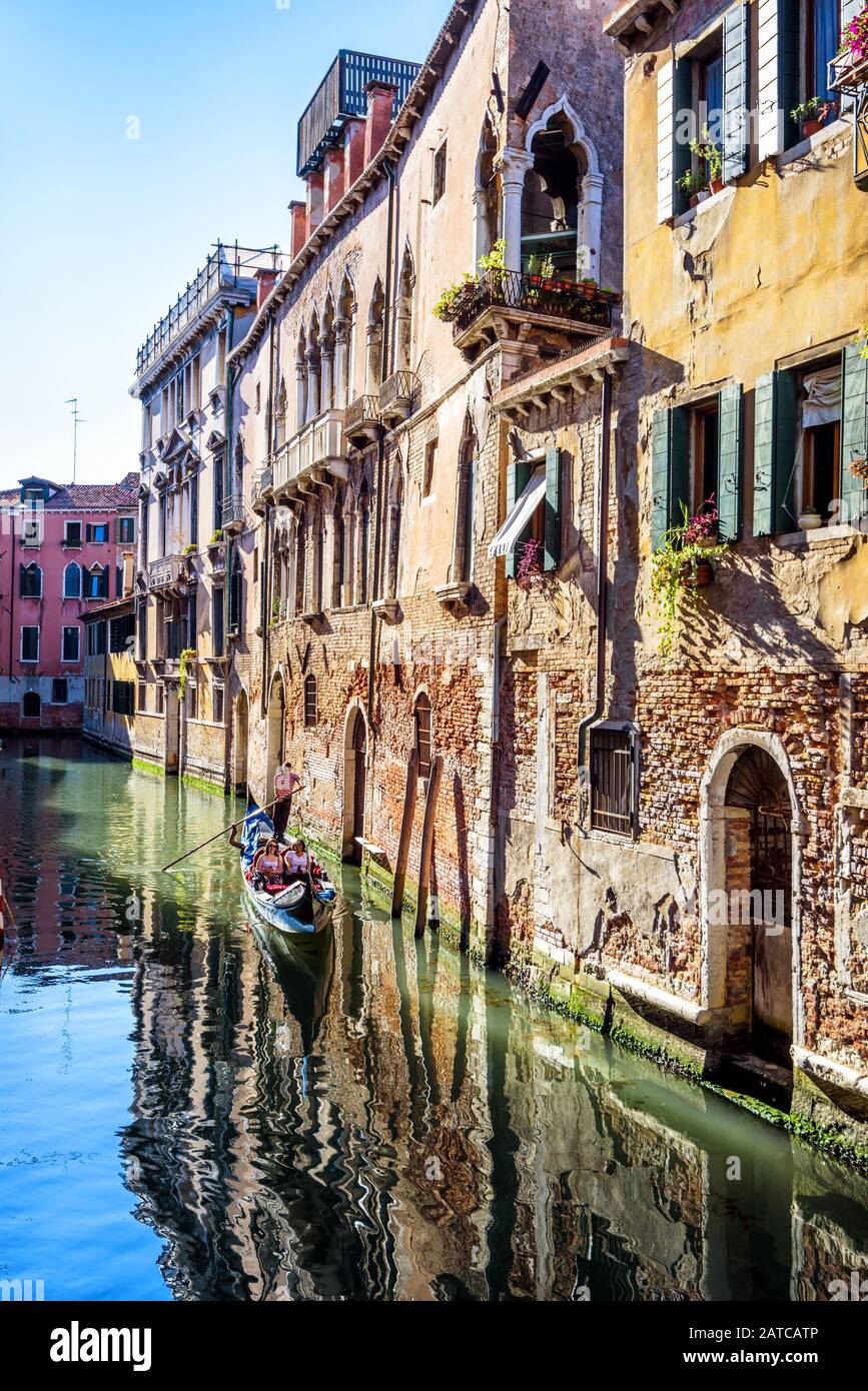 Venedig, Italien - 21. Mai 2019: Gondel mit Touristen segelt an alten Häusern in Venedig vorbei. Szenerie der alten Straße mit Wohnhäusern in Venedig ci Stockfoto