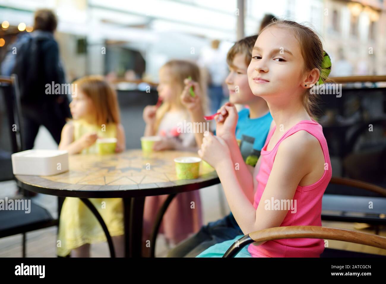 Süße kleine Kinder, die leckeres frisches Eis im Café im Freien essen. Kinder, die Süßigkeiten essen. Ungesundes Essen für Kinder. Stockfoto