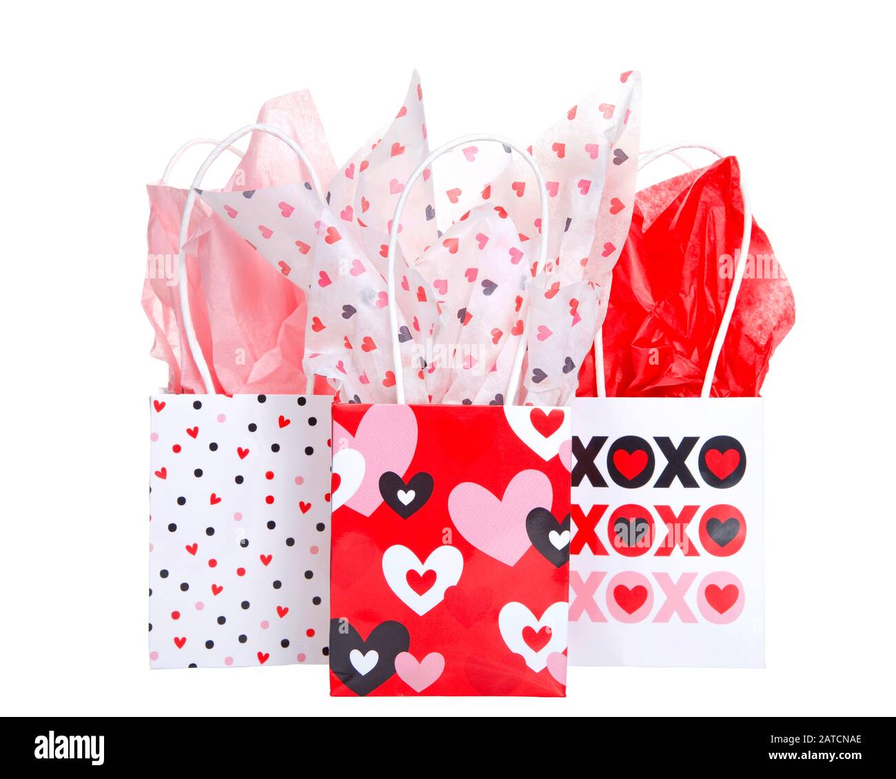 Helle festliche Geschenkbeutel zum Valentinstag in festlichen Farben und Designs mit farbenfrohem Seidenpapier, isoliert auf Weiß. Stockfoto