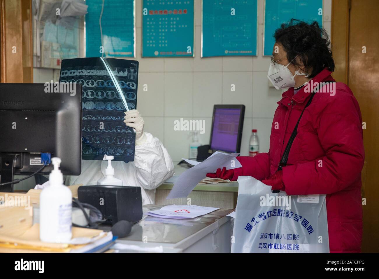 Ein chinesischer Arzt, der Schutzkleidung und eine Gesichtsmaske zur Vorbeugung des neuen Coronavirus trägt, und eine Pneumonie diagnostiziert einen Patienten in einem Krankenhaus Stockfoto