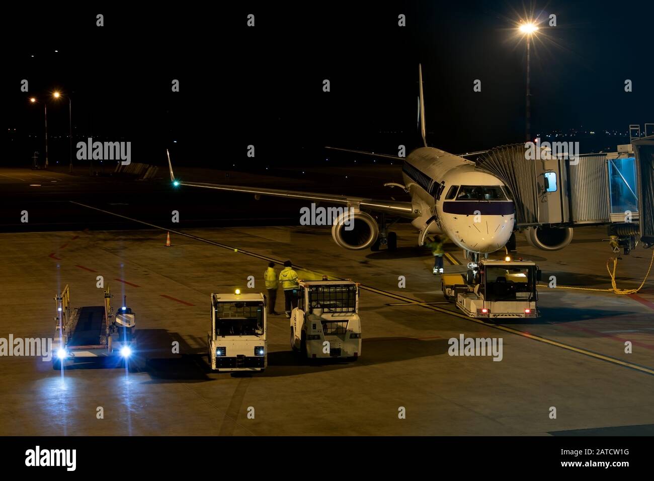 Das Flugzeug wird am Terminal geparkt. Verkehr am Nachtflughafen. Stockfoto
