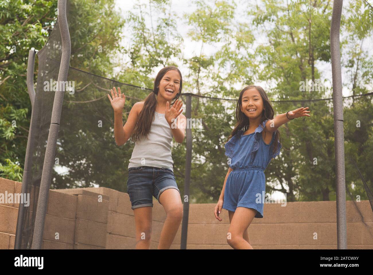 Kleine Mädchen springen und spielen auf einem Trampolin. Stockfoto