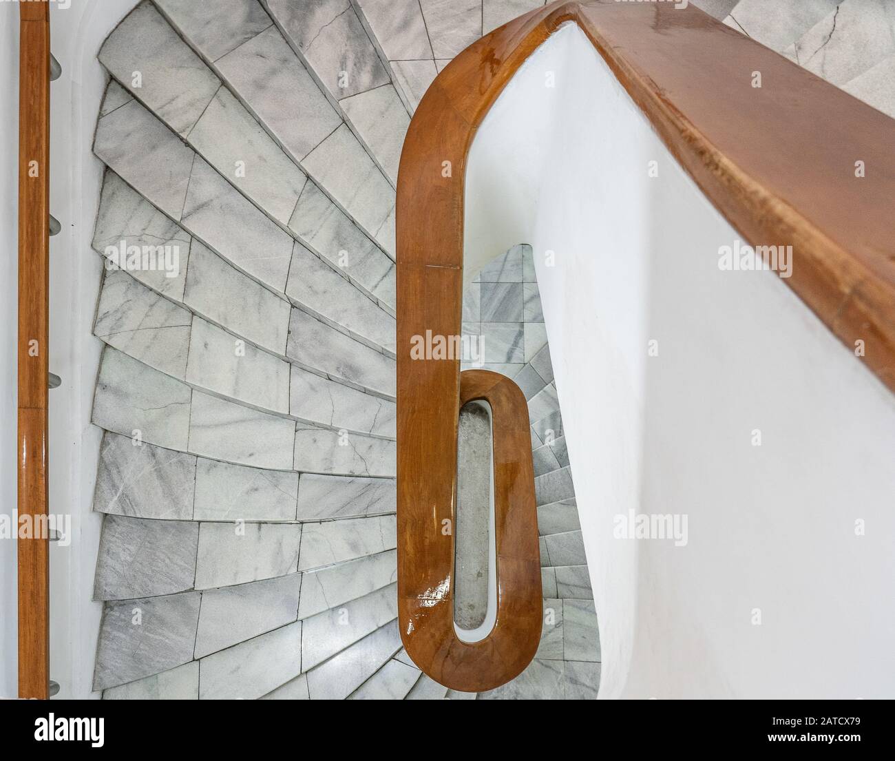 Hohe Winkelaufnahme einer weißen Treppe mit braunem Holz Geländer Stockfoto