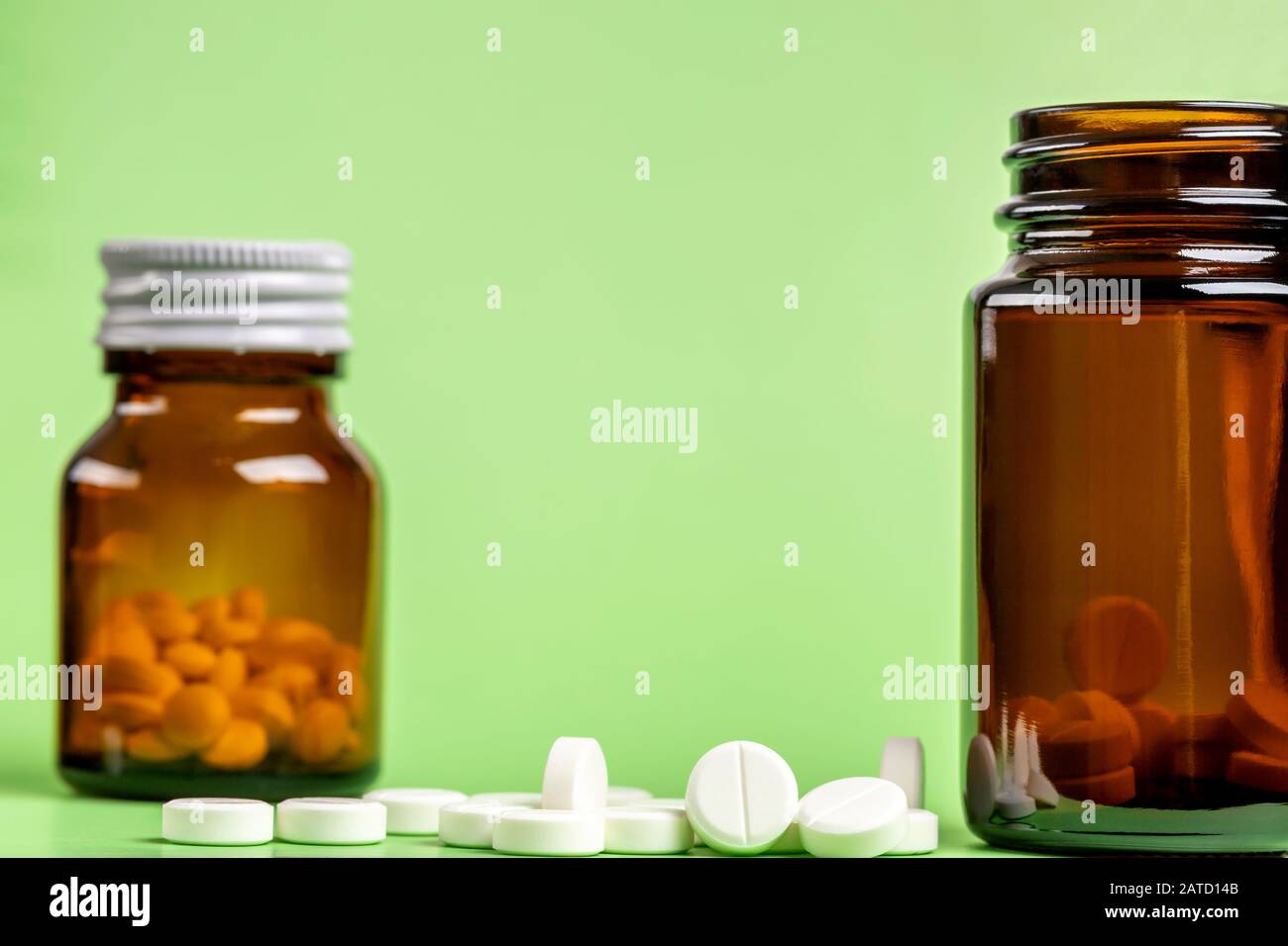 Glas- und Kunststoffflaschen mit weißen Tabletten im Inneren Stockfoto