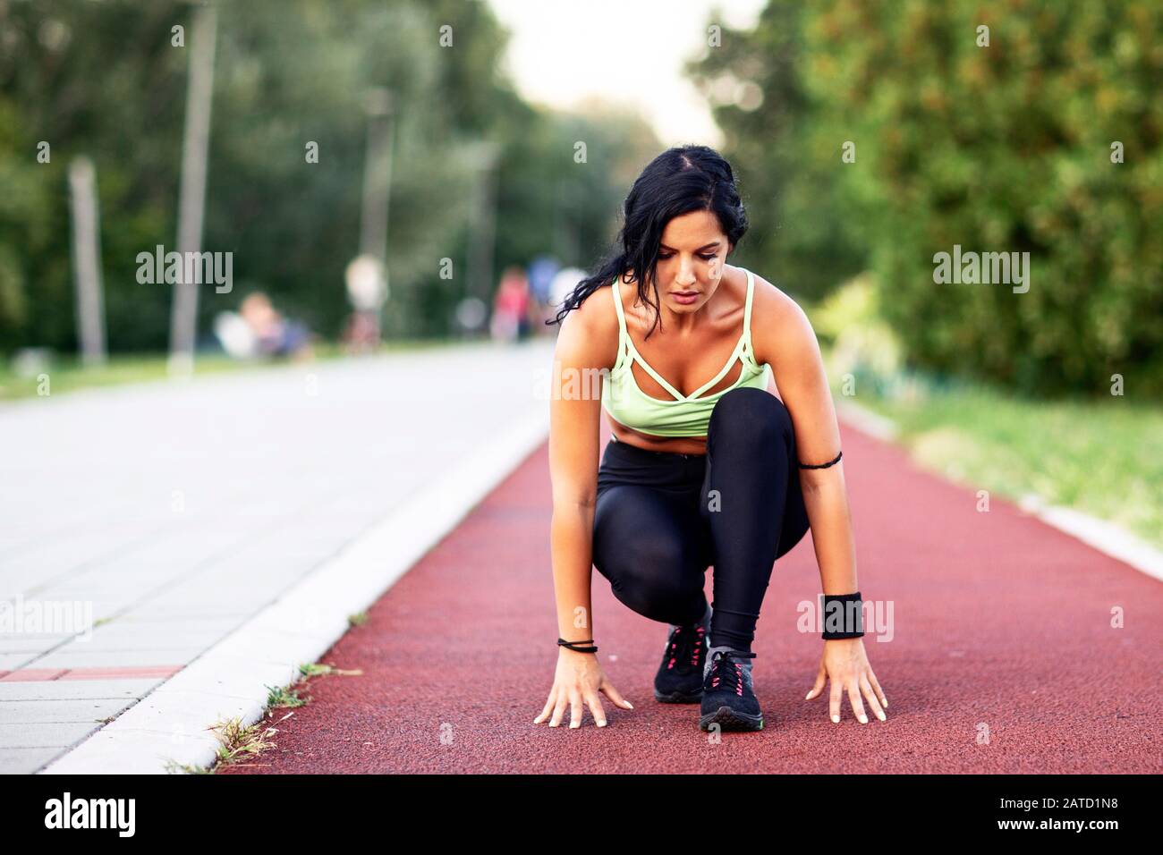 Fitness-Frau in Sportbekleidung auf der Tatort-Bahn Stockfoto