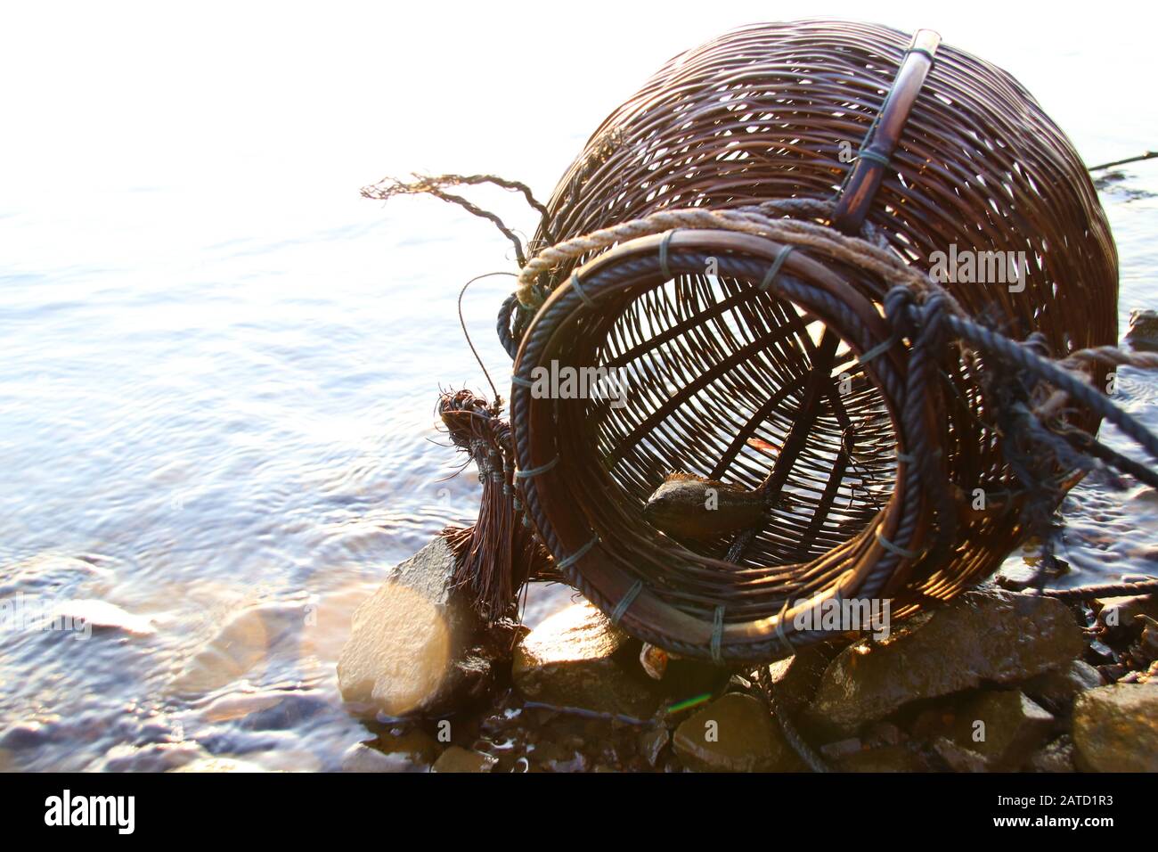 Gewebte Rattancreel oder Fischerkorb, ein traditioneller Fischcontainer in einem ländlichen Fischerdorf in Kambodscha, das authentisches Leben und Kultur zeigt Stockfoto