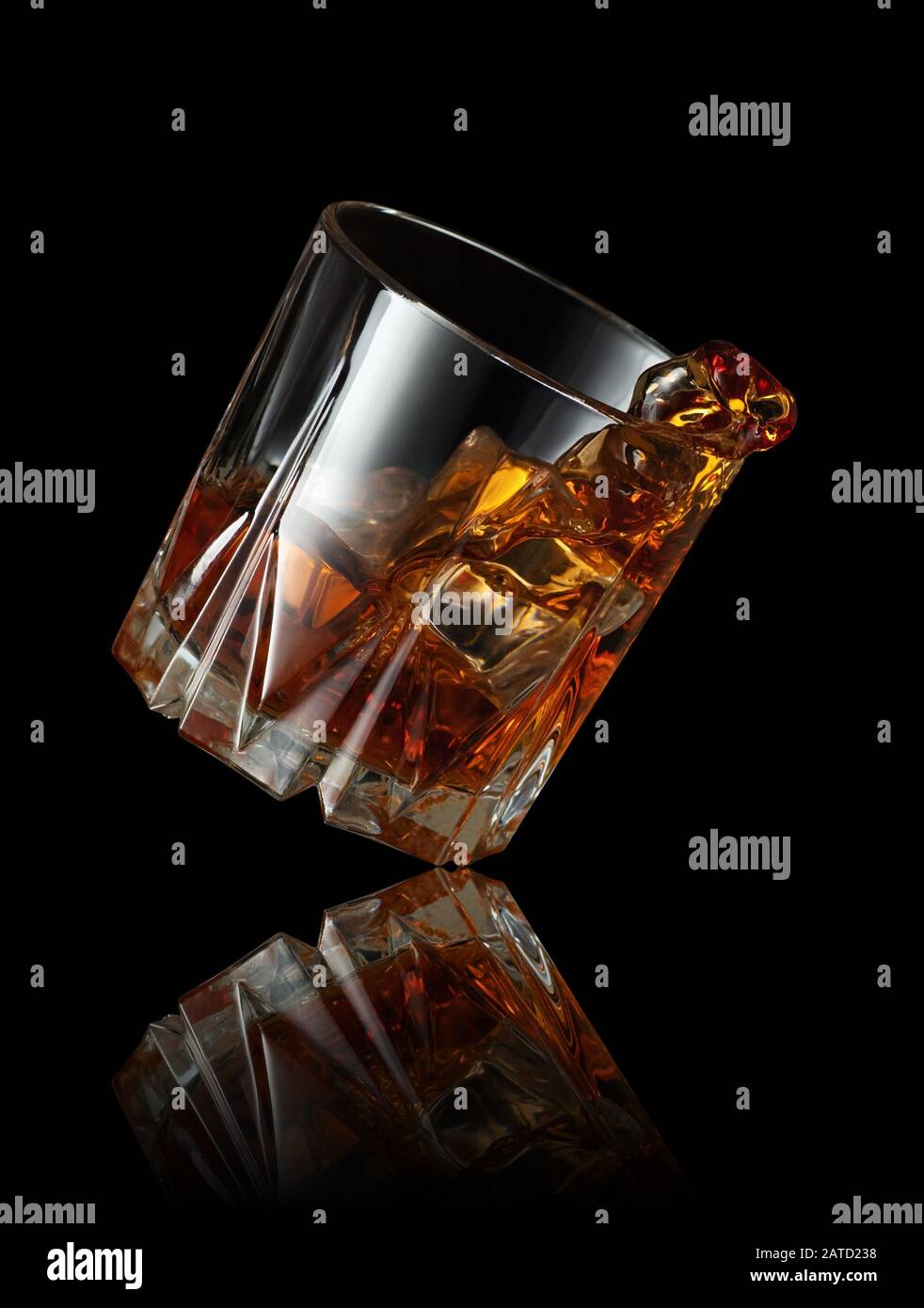 Splash Whisky mit Eiswürfel im Glas auf schwarzem Hintergrund Stockfoto