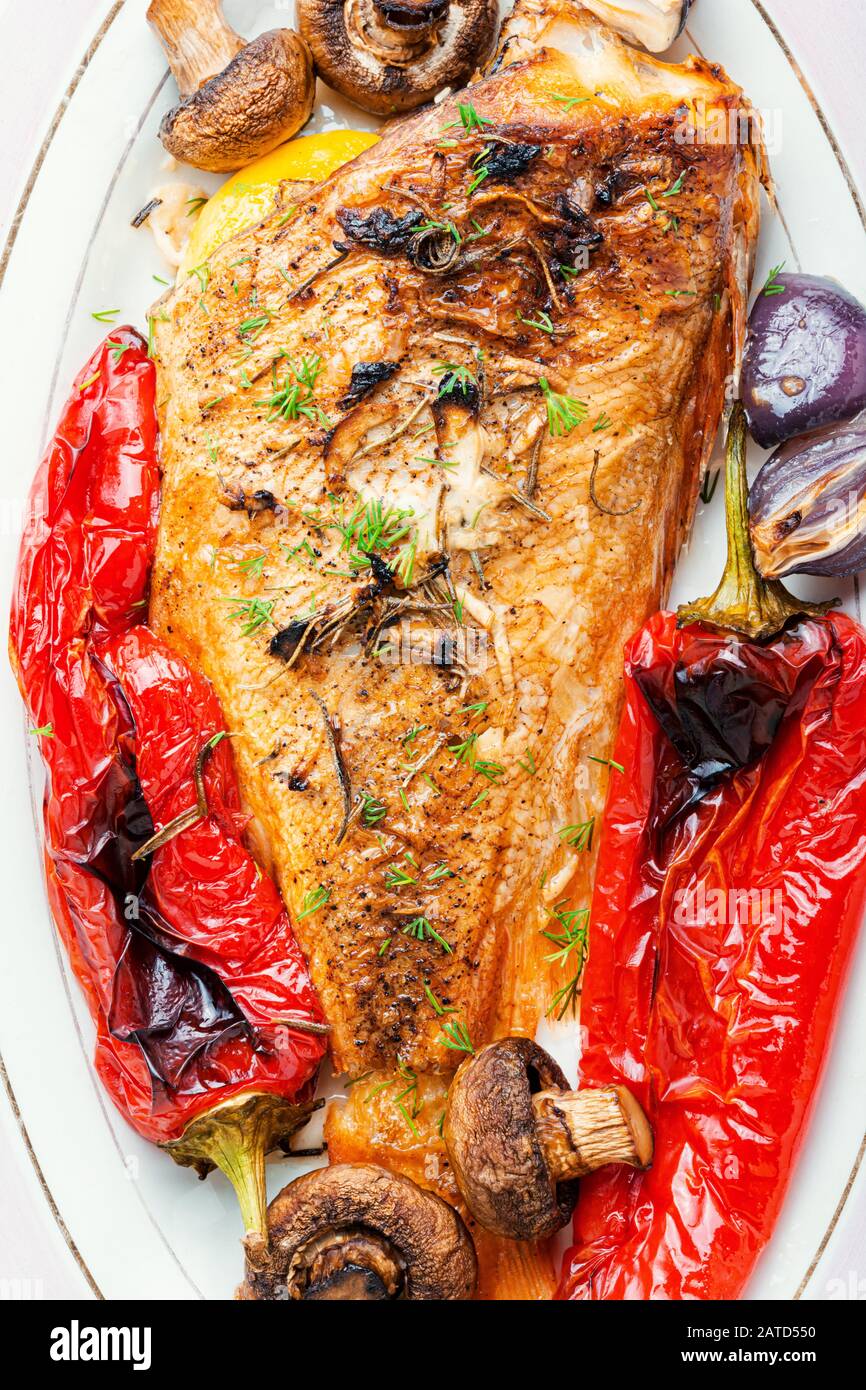 Diätetischer Roter Perch mit Pilzen und rotem Pfeffer gebacken.Fisch im Gemüse gebacken.Roter Meerbarsch Stockfoto