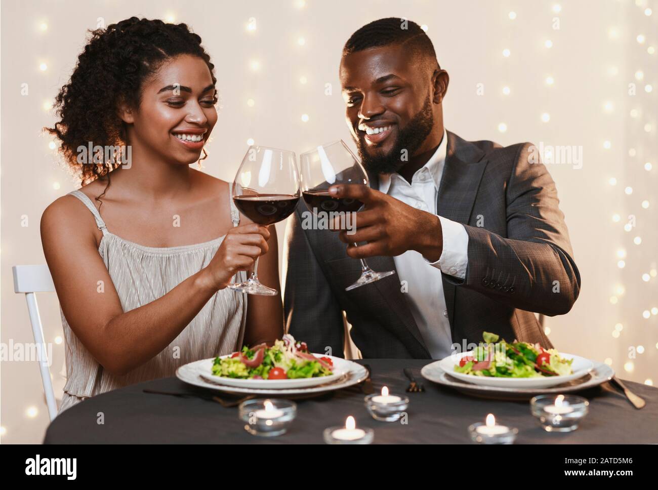 Fröhliches schwarzes Paar in Liebe zum Toasten im Restaurant Stockfoto