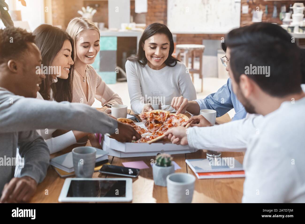 Internationale Kollegen, die während eines Geschäftstreffen eine Pizza-Pause einlegen Stockfoto