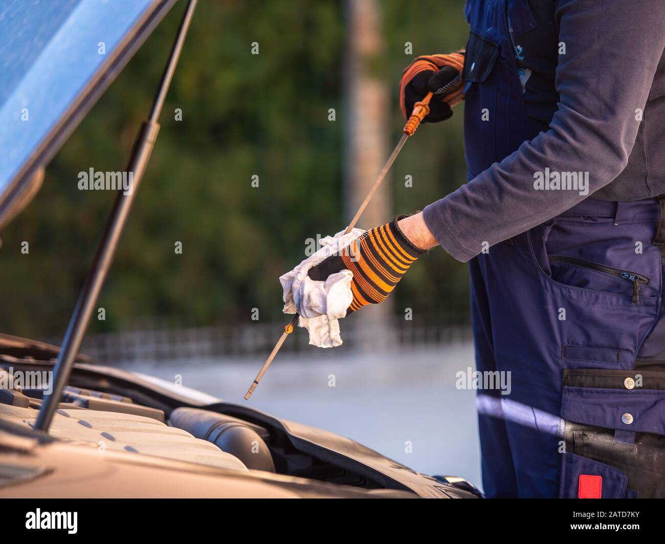 Hand des Kfz-Mechanikers Motoröl auf Wartung prüfen. Stockfoto