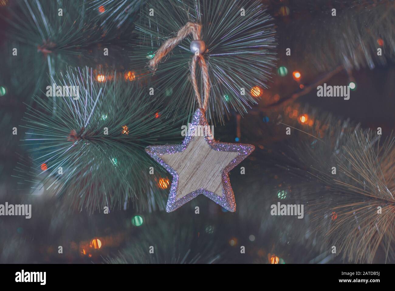 Nahaufnahme eines Weihnachtsstars, der an einem Weihnachtsbaum hängt Stockfoto