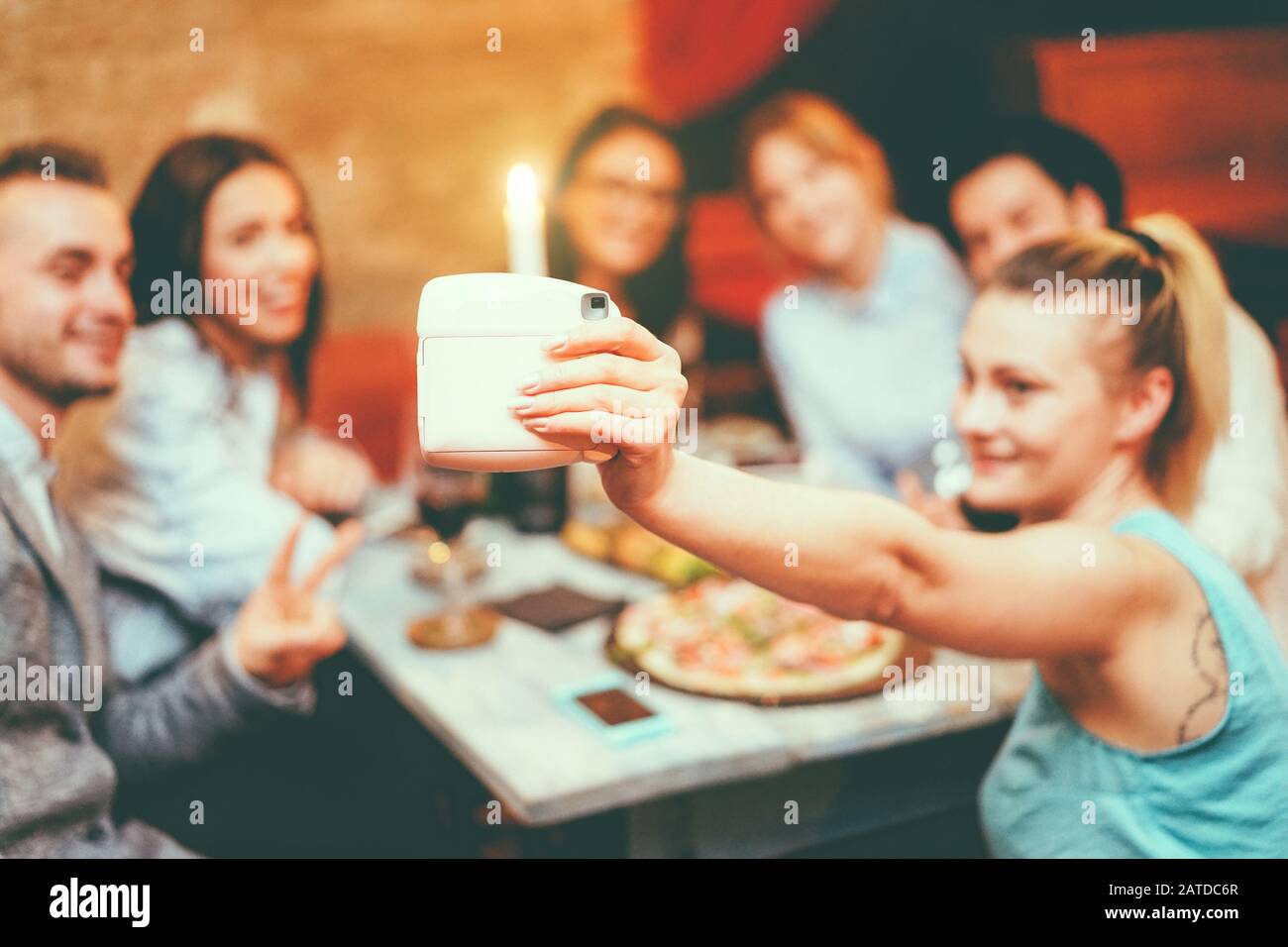 Fröhliche Freunde, die selfie mit Sofortkamera in einem trendigen Cocktailbar Restaurant einnehmen - Junge Leute, die sich vor dem Abendessen mit Vorspeise verwöhnen lassen - Youth tec Stockfoto