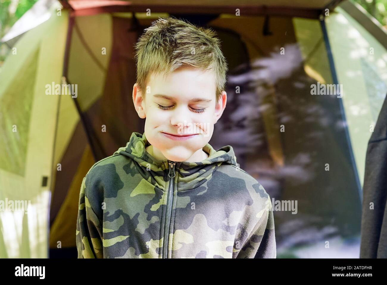 Der Junge beim Picknick machte ein fröhliches Gesicht mit aufgeblasenen Wangen. Stockfoto
