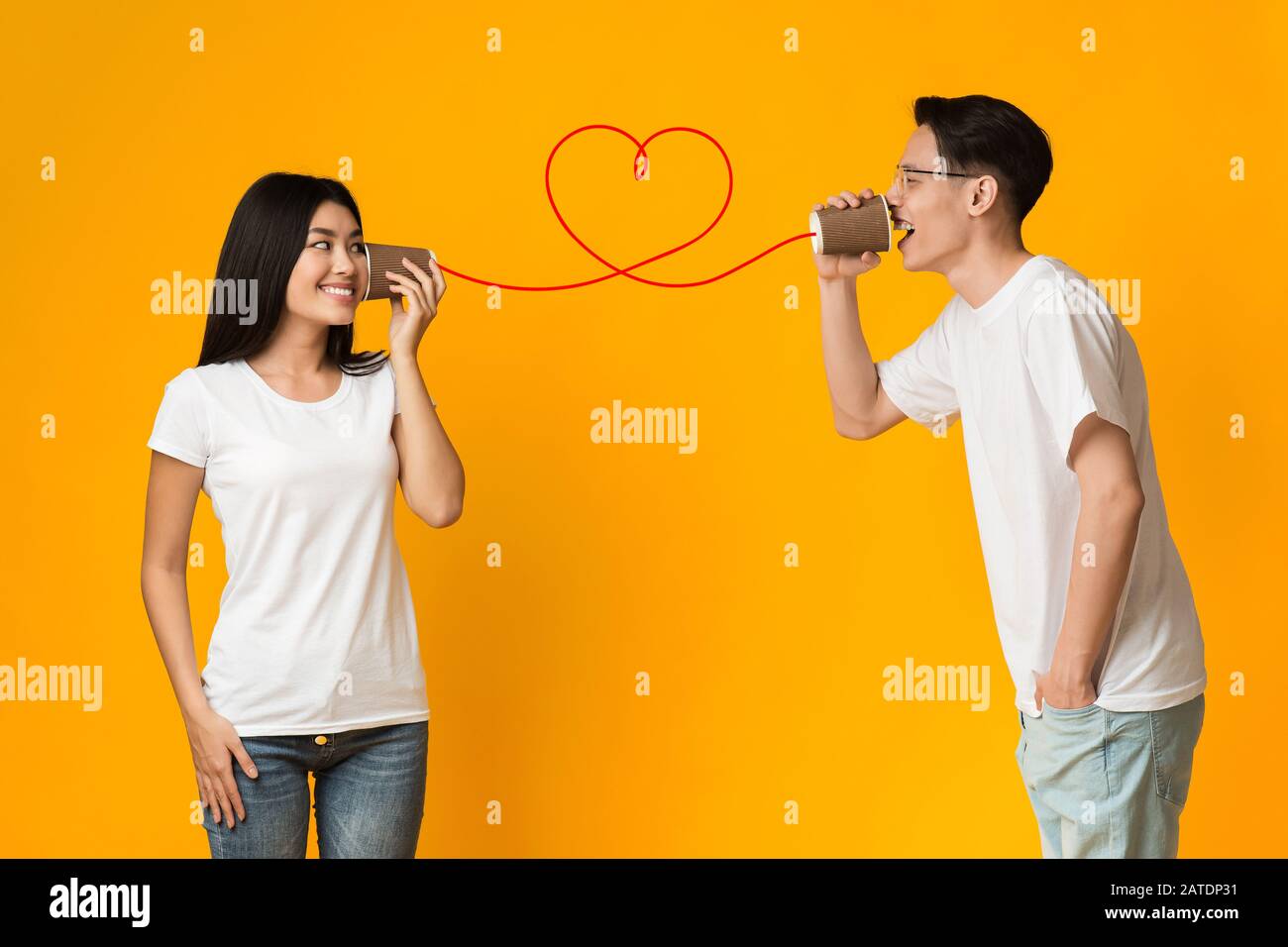 Asiatischer Kerl erzählt Freundin über Liebe, mit CAN-Telefon Stockfoto