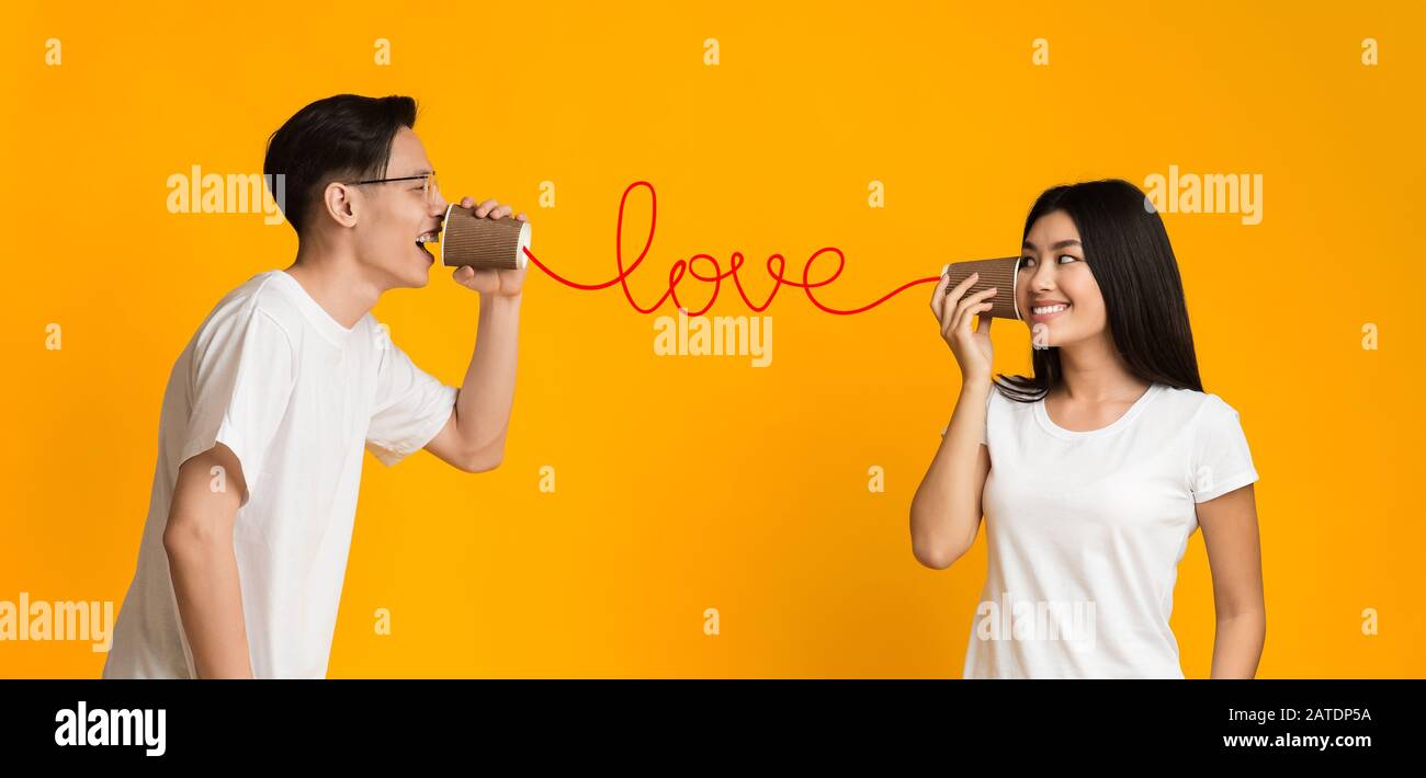 Asiatische Paare teilen Gefühle über CAN-Telefon Stockfoto