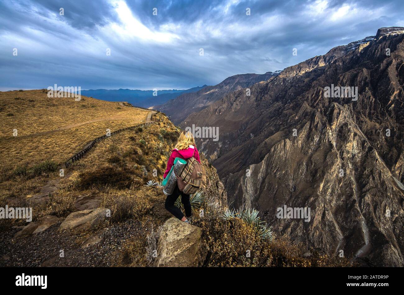 Junge Frau meditiert über dem tiefsten Canyon Colca. Atemberaubende Panoramasicht auf das peruanische Dorf und den Canyon Colca, Peru, Südamerika Stockfoto