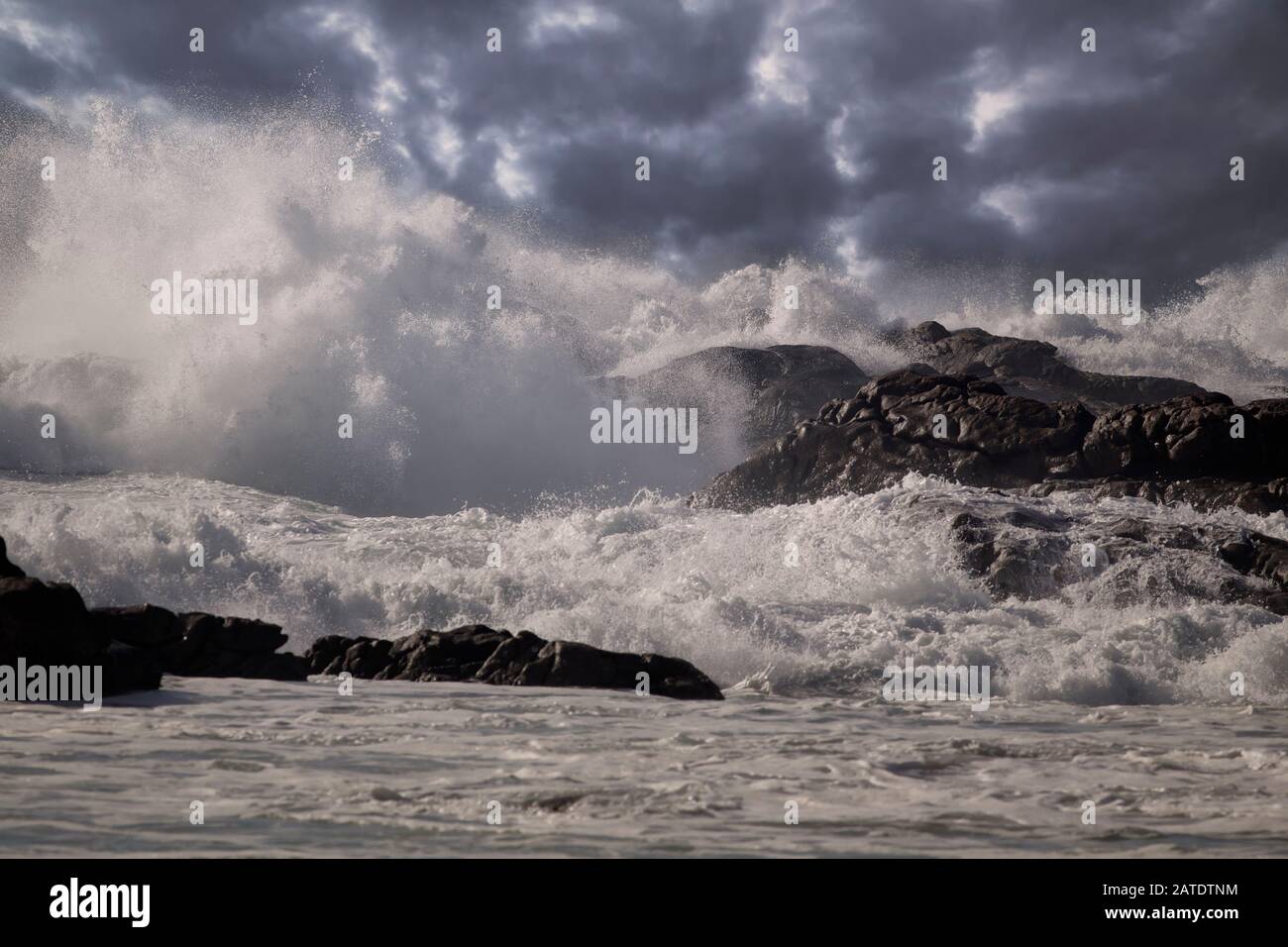 Stürmische Wellen spritzen. Verbesserter Himmel. nordportugiesische Felsküste. Stockfoto