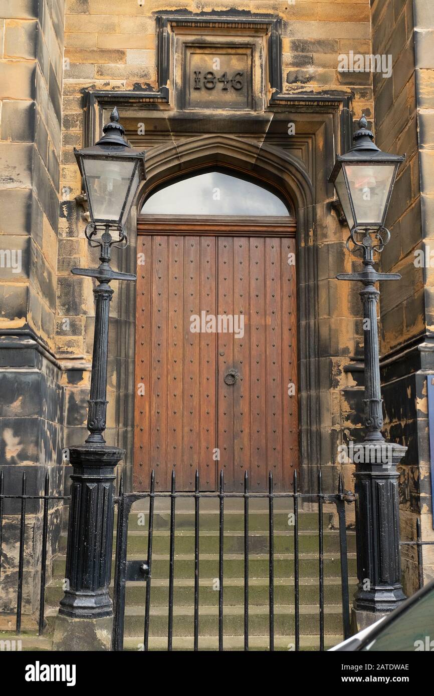 Alte große viktorianische Holztür (1846) und alte Straßenbeleuchtung in der Assembly Hall in Edinburgh, Schottland Stockfoto