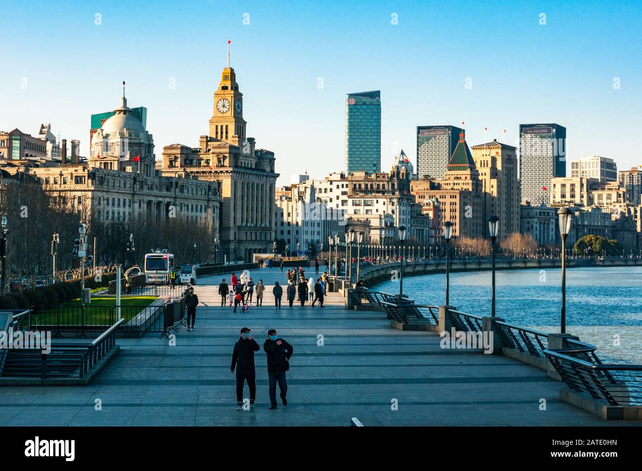 Shanghais meist gepackter Bund-Gehweg ist wegen des Coronavirus mit ein paar tapferen Touristen und den dahinter liegenden historischen Bund-Gebäuden fast leer. Stockfoto