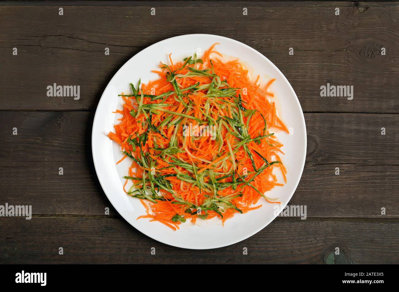 Gemüsesalat mit Karotte und Gurke auf Holztisch, Draufsicht Stockfoto