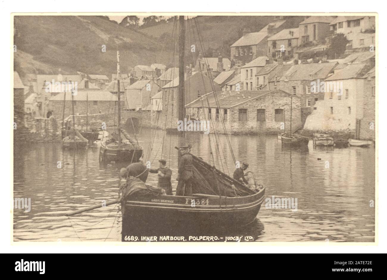 Postkarte des frühen 20. Jahrhunderts mit malerischem Binnenhafen, mit Fischer und seinem Boot, Polperro, Cornwall, England, Großbritannien um 1920 Stockfoto