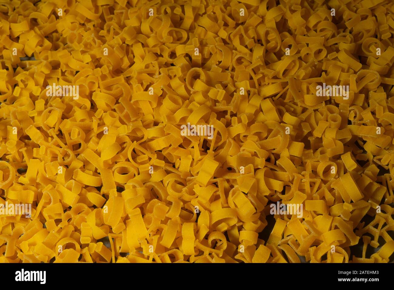 Pasta in Form von Buchstaben des englischen Alphabets und Zahlen. Nahaufnahme. Ansicht von oben. Kreativer Vintage-Hintergrund. Stockfoto