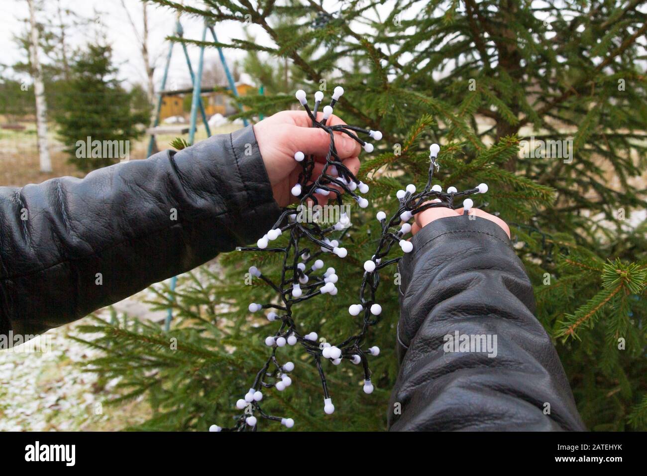Weihnachtsbaumschmuck mit buntem Girland auf der Straße im Winter Stockfoto