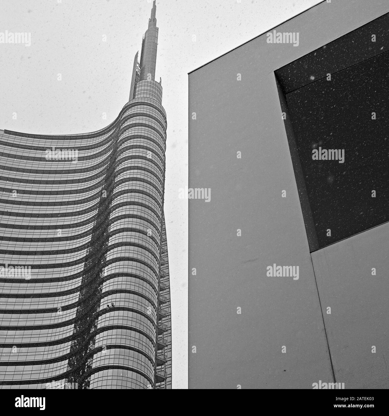 Geometrische Perspektive und Kontrast der Formen zwischen dem Unicredit Tower und einem Wandfenster des nahe gelegenen Gebäudes auf der Piazza Gae Aulentiti, Mailand, Italien Stockfoto