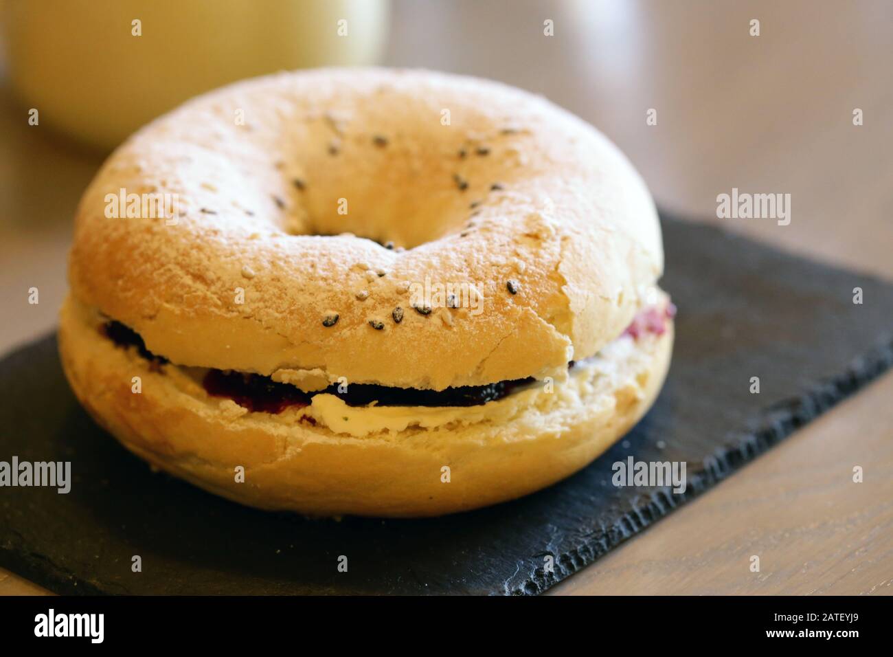 Frühstücksbagel mit Belägen und Kaffee auf dem Tisch Stockfoto
