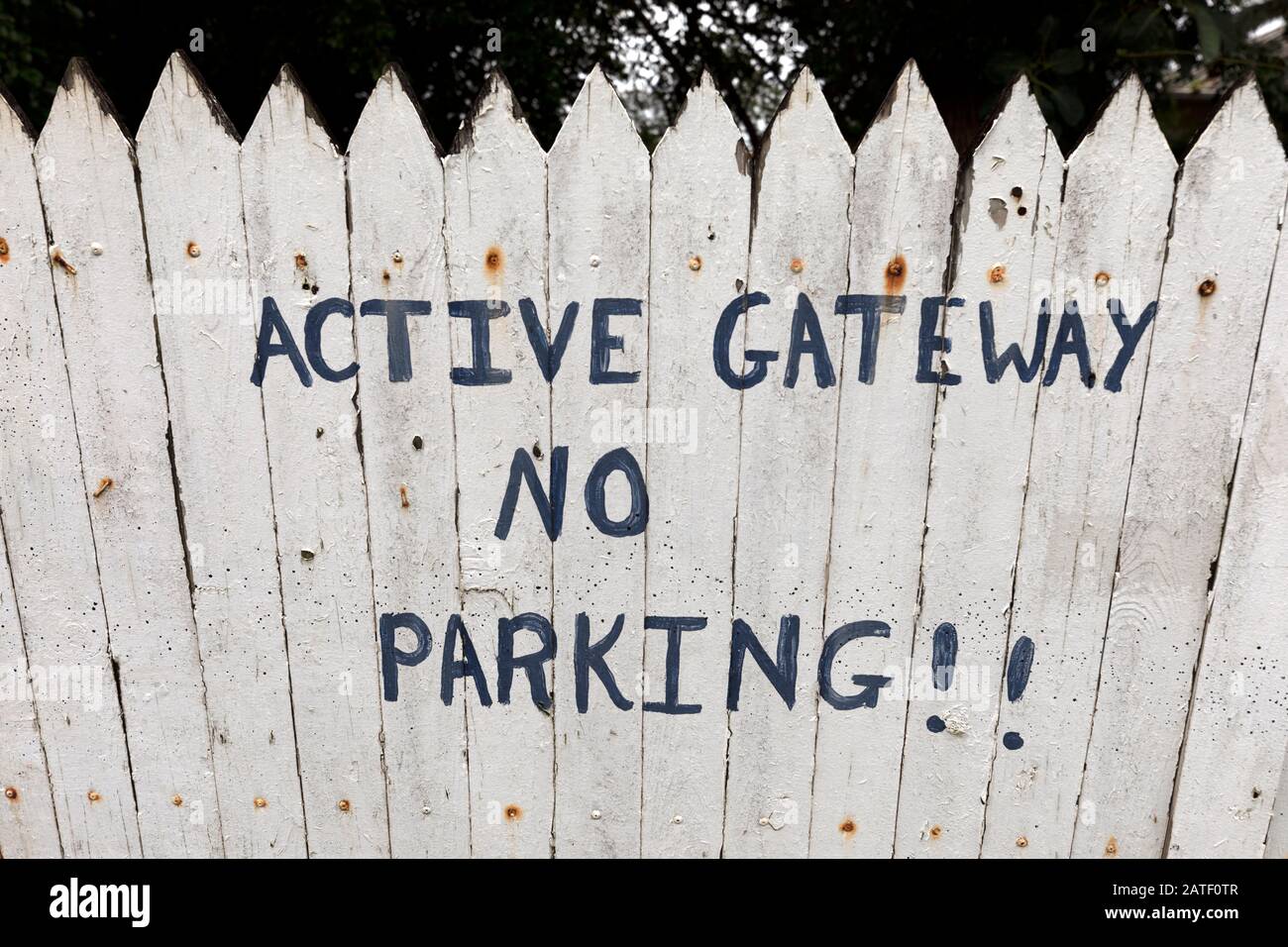 Active Gateway kein Parkplatz, der auf einen weißen Picket-Zaun gemalt wurde Stockfoto