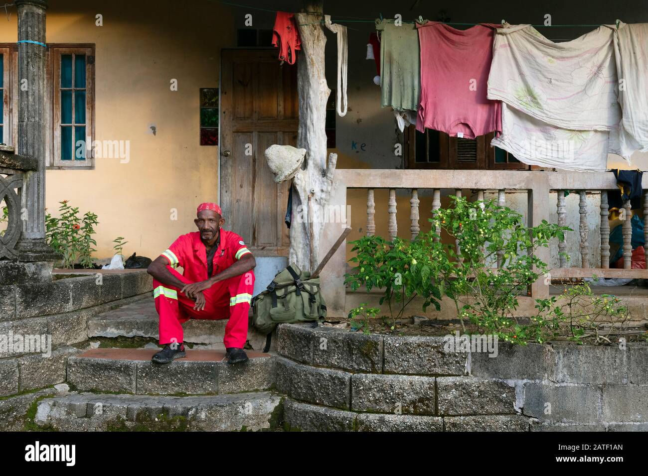 Mann sitzt vor seinem Haus, Grand Riviere, Trinidad und Tobago Stockfoto
