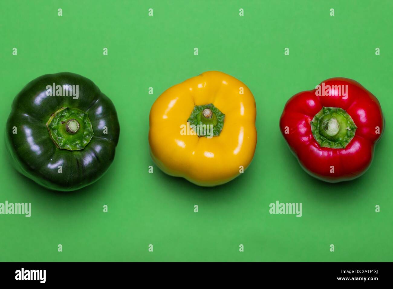 Grüne, gelbe und rote Paprika auf hellgrünem Hintergrund. Frisches Gemüse in natürlichen Farben. Lebensmittelkonzept für gesunde Ernährung Stockfoto