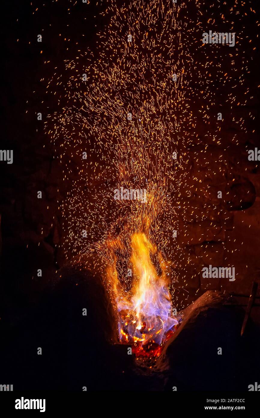 Schmiede Feuer Flamme Tipps mit Funken closeup auf dunklem Hintergrund Stockfoto