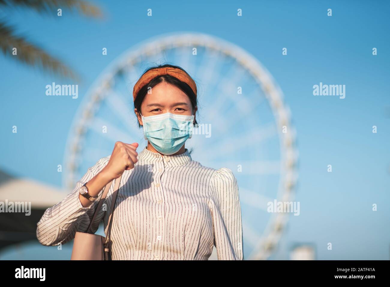 Asiatische Mädchen tragen Gesichtsmaske, um Virus an der Bushaltestelle zu verhindern Stockfoto