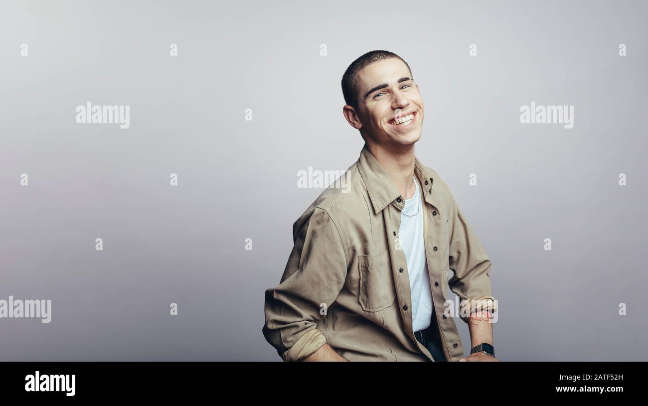 Porträt eines lächelnden Mannes isoliert auf grauem Hintergrund. Junger kaukasischer Mann mit Blick auf die Kamera. Stockfoto