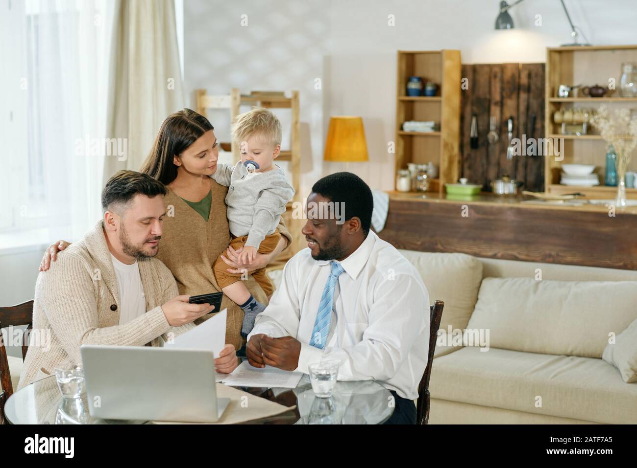 Junge Familie und Finanzberater zu Hause Stockfoto