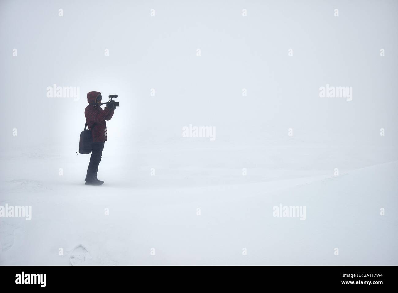 Einsamer Fotograf mit Fotocamera-Aufnahmen im Winterfeld Stockfoto