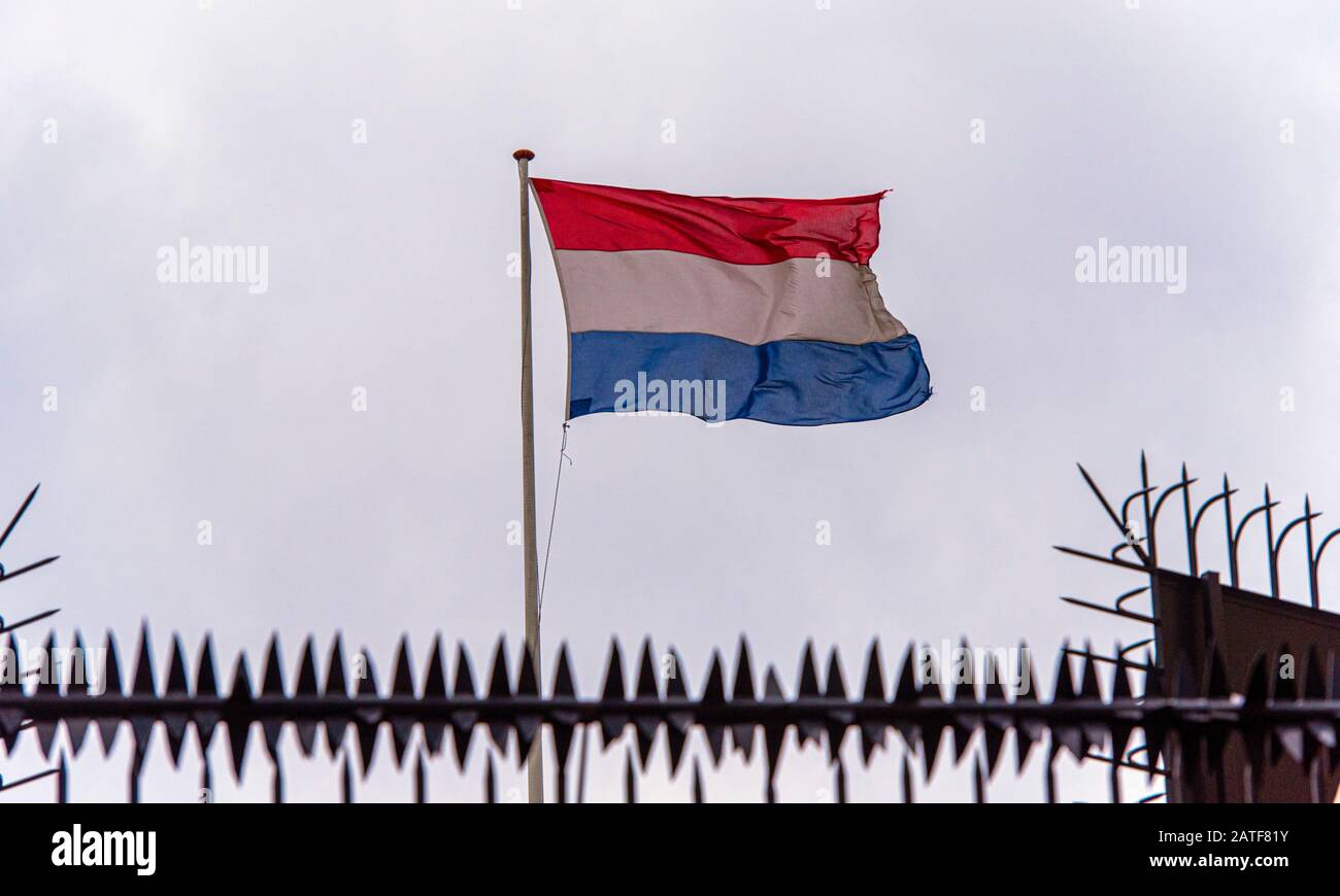 Niederländische Grenze, niederländische Flagge neben Embassy Fence, gezont Bild Stockfoto