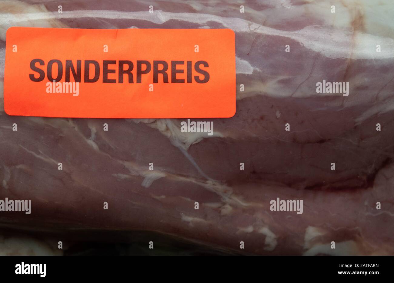 Stuttgart, Deutschland. Januar 2020. Auf einem Stück Schweinefleisch ist ein Aufkleber mit den Worten "Sonderpreis" aufgeklebt. Vertreter des Einzelhandels, der Lebensmittelindustrie, des Landwirtschaftsministers Klöckner und des Wirtschaftsministers Altmaier (beide CDU) treffen sich am 3. Februar mit Kanzlerin Merkel (CDU). Zu den Diskussionsthemen gehören günstige Angebote, gegen die auch die Landwirte protestieren. Credit: Sebastian Gollnow / dpa / Alamy Live News Stockfoto