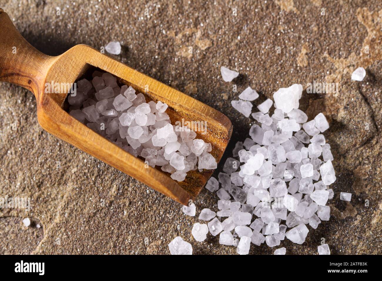 Grobes Salz mit Messlöffel Stockfoto