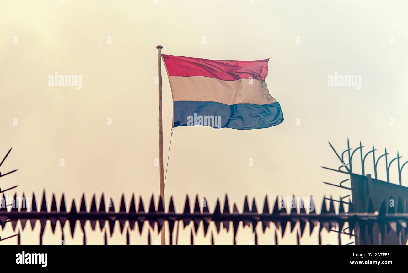 Niederländische Grenze, niederländische Flagge neben Embassy Fence, gezont Bild Stockfoto