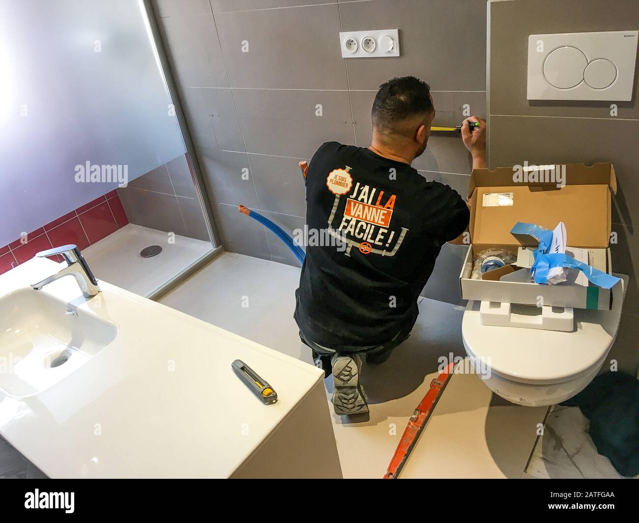 Ein Installateur auf einer Baustelle im Bad, Lyon, Frankreich Stockfoto