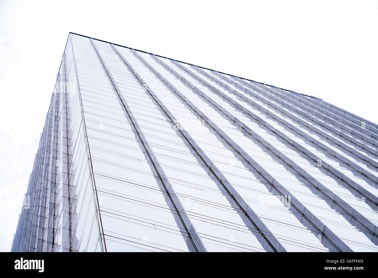 Ein minimalistisches, abstraktes Bild mit niedrigem Winkel von Gebäudefenstern mit blauer Farbton. Stockfoto
