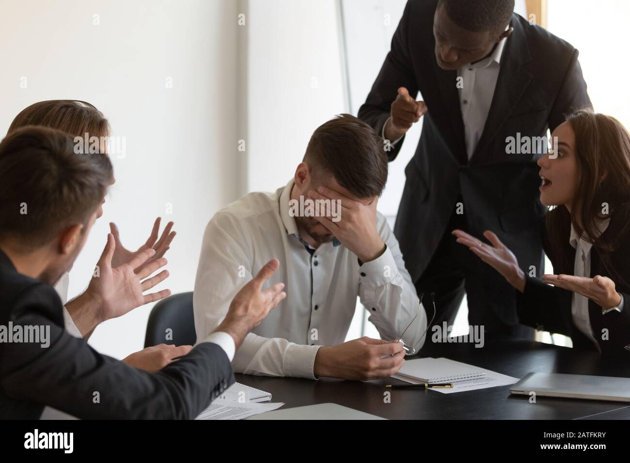 Frustrierter Mitarbeiter fühlt sich gestresst und leidet unter feindseligen Kollegen Stockfoto