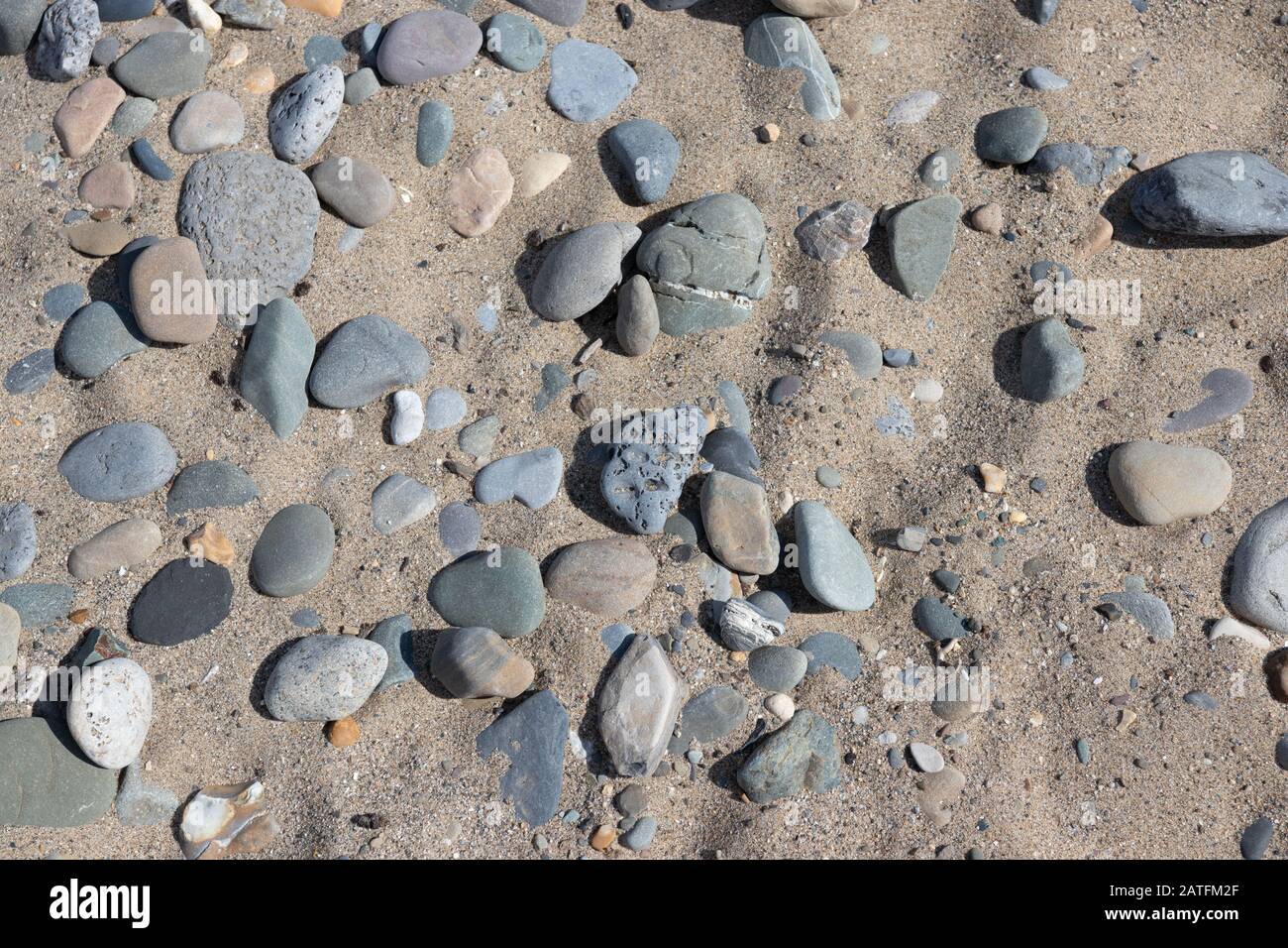 Meeressteine Hintergrund. Graue, weiße Steine am Strand Stockfoto