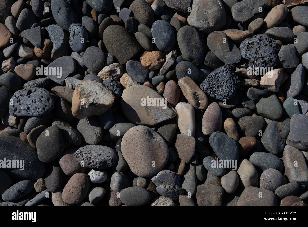 Meeressteine Hintergrund. Graue, weiße Steine am Strand Stockfoto