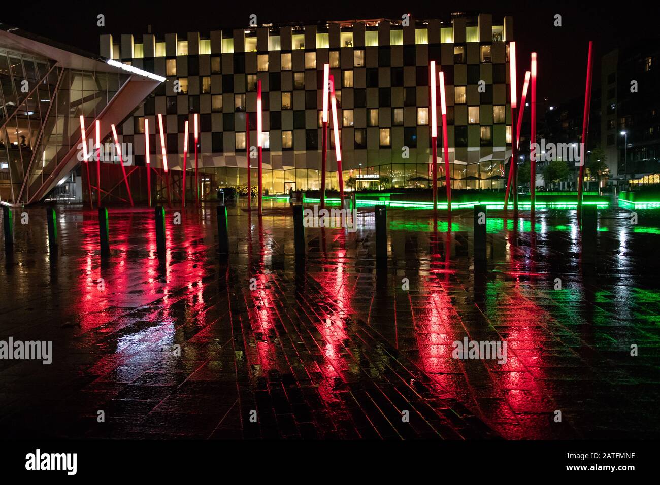 Blick auf den Grand Canal Square bei Nacht in Dublins erneuerten Docklands mit roten Säulen, die zufällig stehen. Irland September 2019 Stockfoto