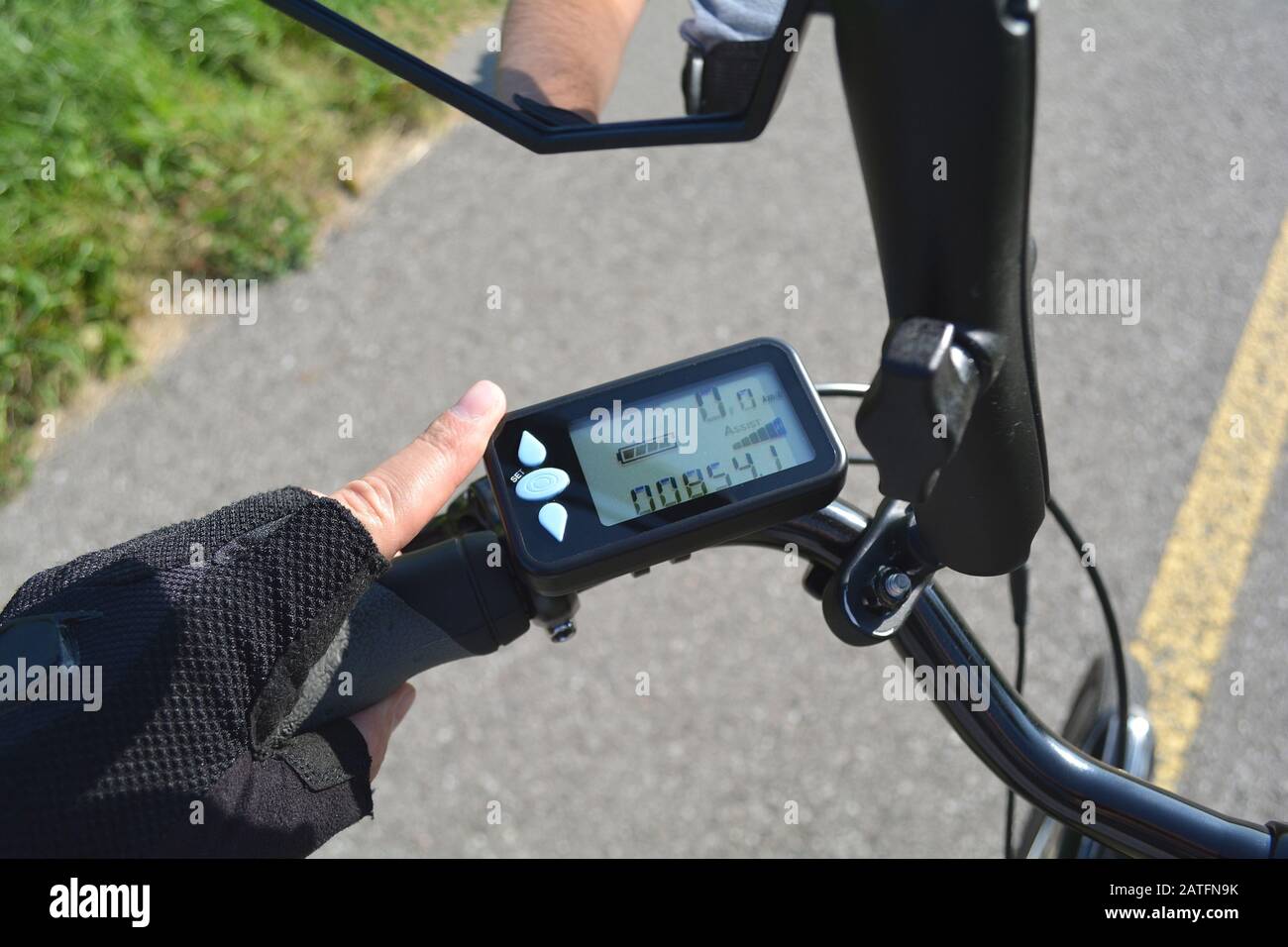 Mann schaltet sich mit Elektro-Bike oder E-Bike ein. Bord-Display mit modernem E-Bike. Anzeige von Geschwindigkeit, Leistungsstufe und Distanz in Kilometern. Stockfoto